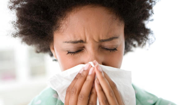 An image of a woman blowing her nose to promote the homeopathic patches for allergy relief from Frequency Apps.