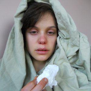 An image of a person with a red nose and tissue with a cold to promote the bacteria-fighting homeopathic patches for cold symptoms from Frequency Apps.
