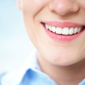 An image of a woman smiling with healthy teeth to promote the medicated patches for dental meridian balance from Frequency Apps.