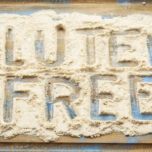 An image of the phrase “Gluten-Free” written with a finger in flour to promote the gluten-free homeopathic patch from Frequency Apps.