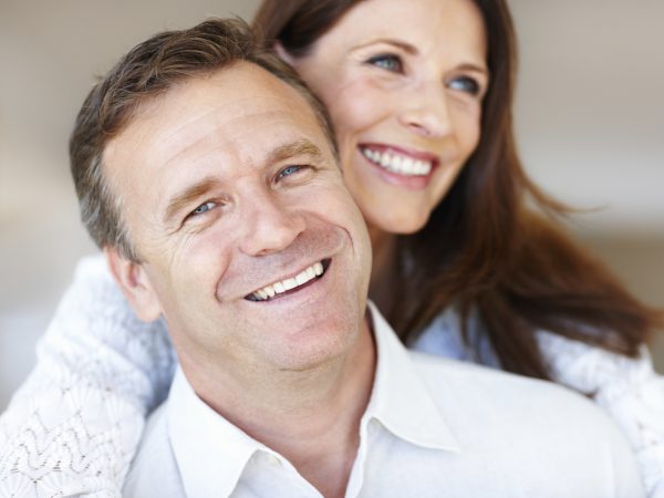 Image of a smiling man with a woman standing behind him, promoting the Male Hormone Balancer patch.