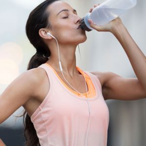 An image of a woman drinking from a water bottle to promote the medicated patches for weight loss with a metabolism booster from Frequency Apps.