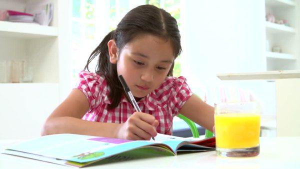 An image of a young girl doing homework to promote the homeopathic patches for children’s mental focus from Frequency Apps.